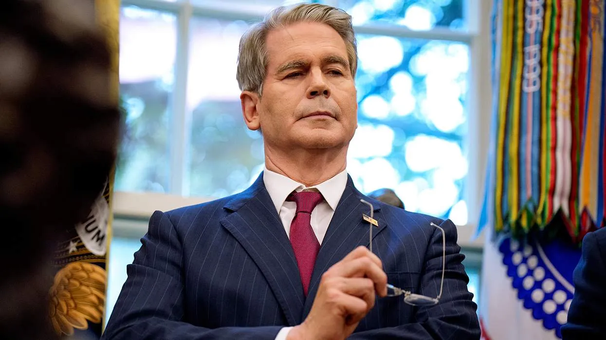 scott-bessent-holding-glasses-in-front-of-a-window